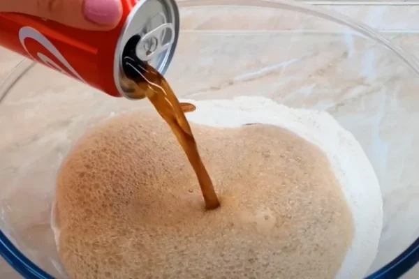 A woman creates very wonderful, fluffy bread by combining flour with cola